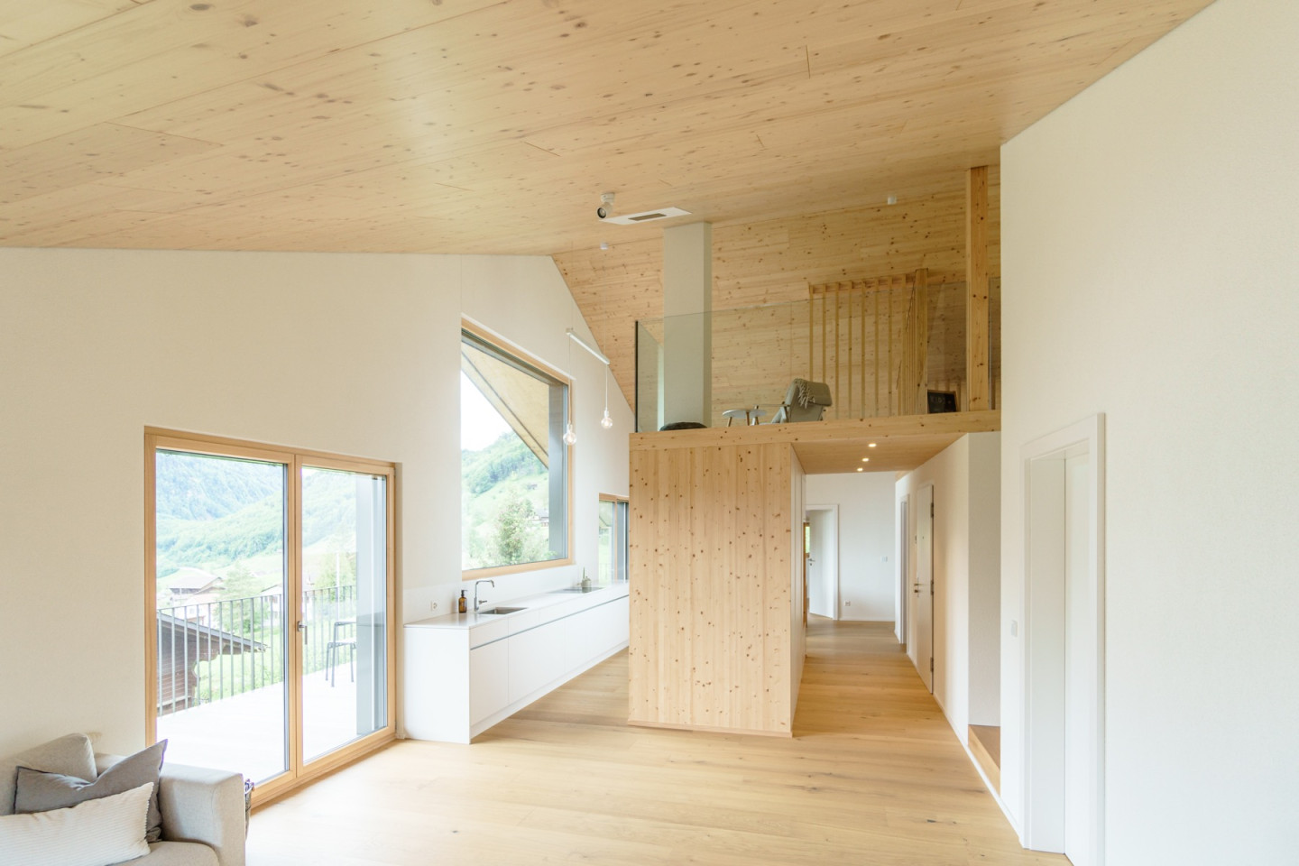 Offener Wohnbereich mit Küche, Galerie im Hintergrund und Blick zum Korridor
