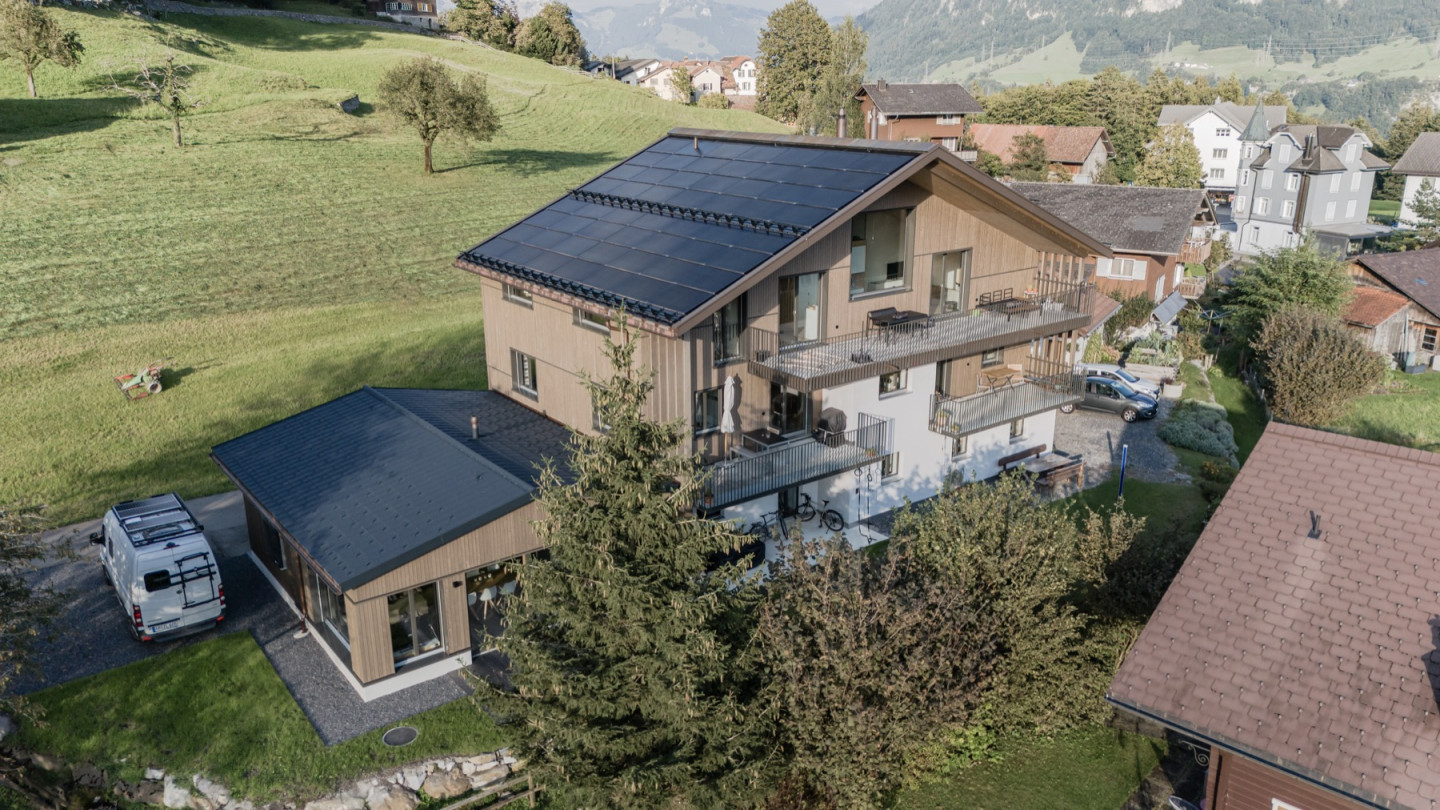 Drohnenaufnahme des Wohnhauses mit Solardach, Balkonen und angrenzendem Anbau